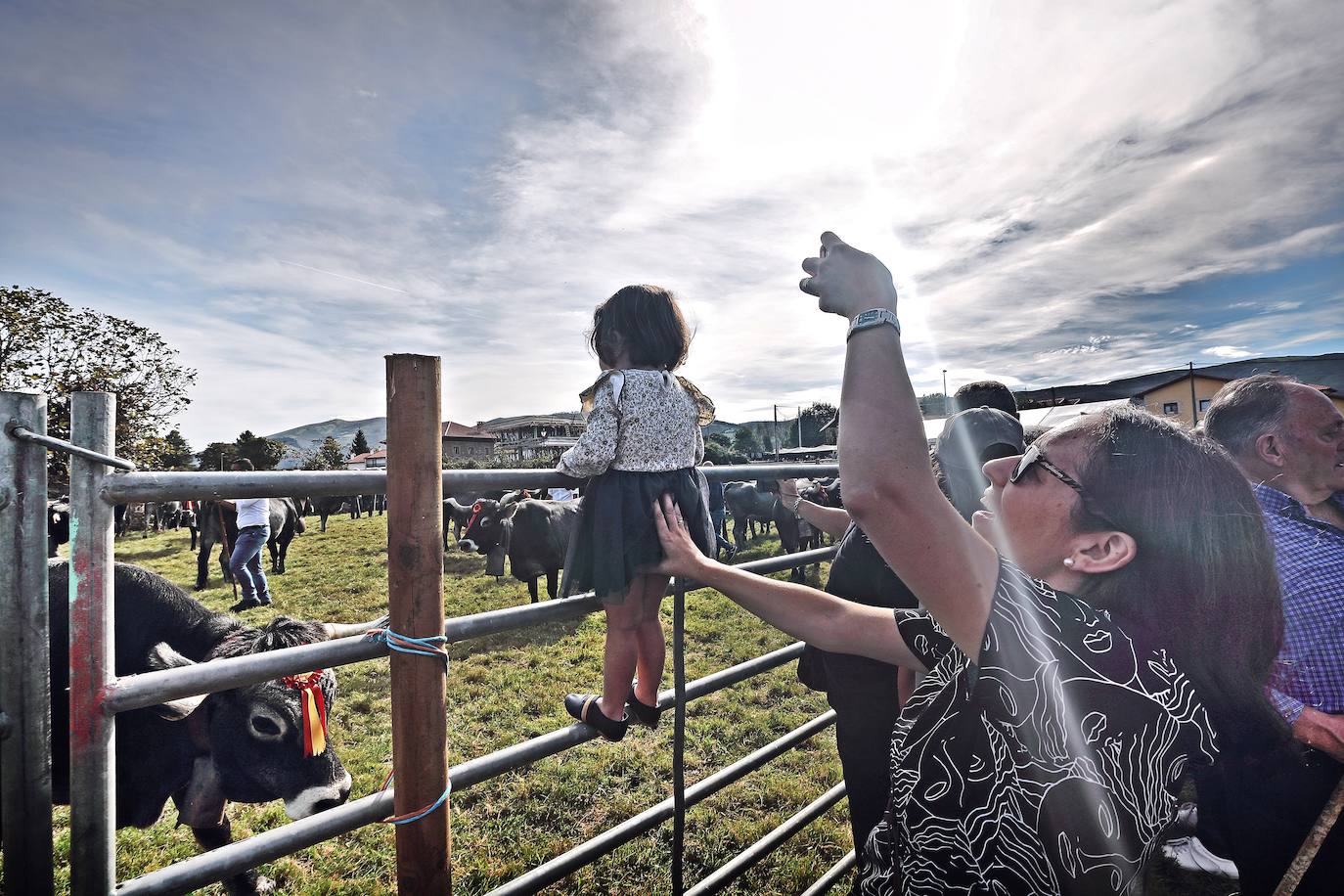 Una madre fotografía con el teléfono a su hija durante la olimpiada de ganado Tudanco en Cabezón de la Sal. Cabezón de la Sal 12-10-2018