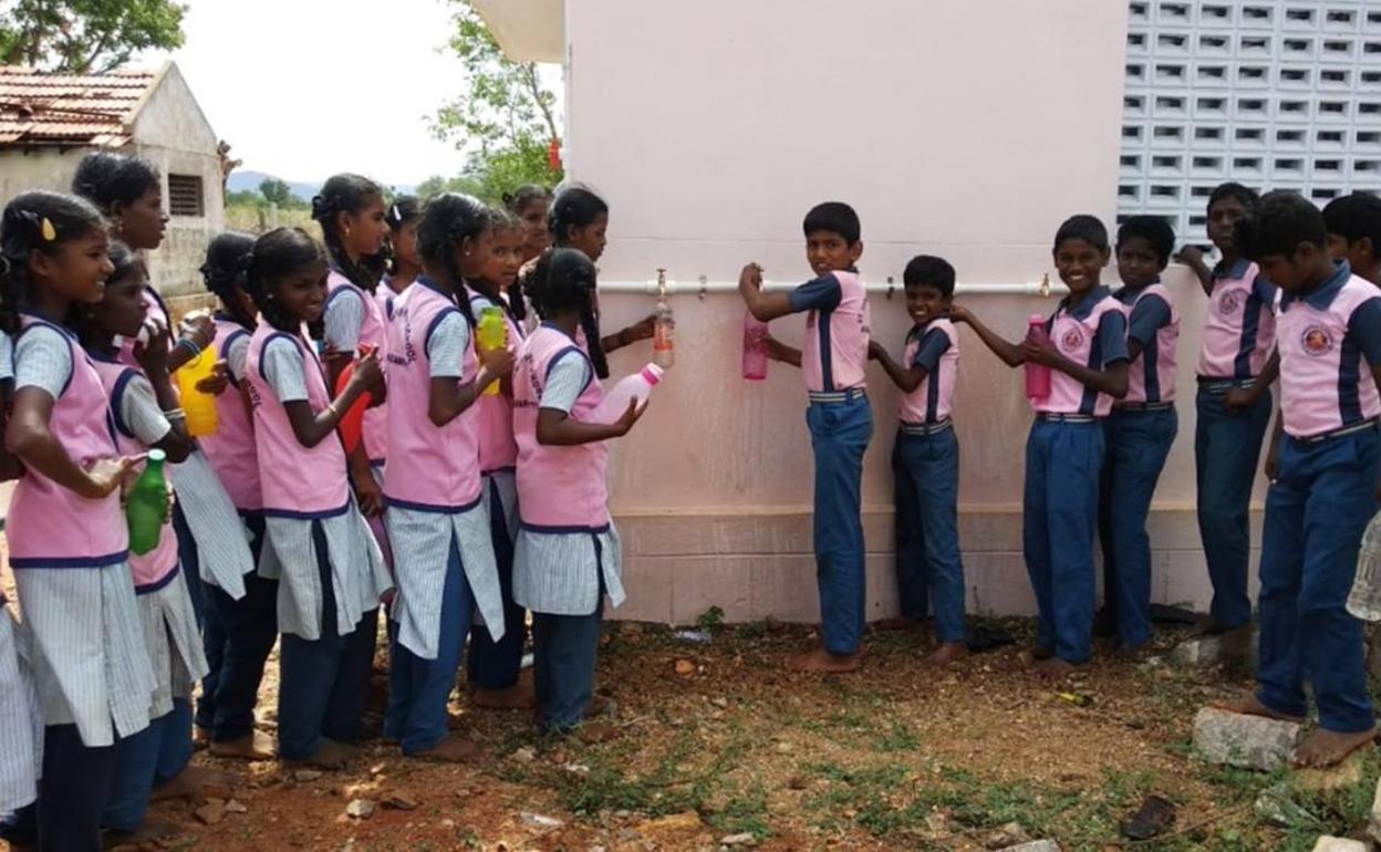 Varios niños cogiendo agua.