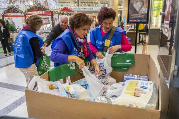 Un grupo de voluntarios recoge y organiza las donaciones solidarias recaudadas en Hipercor.