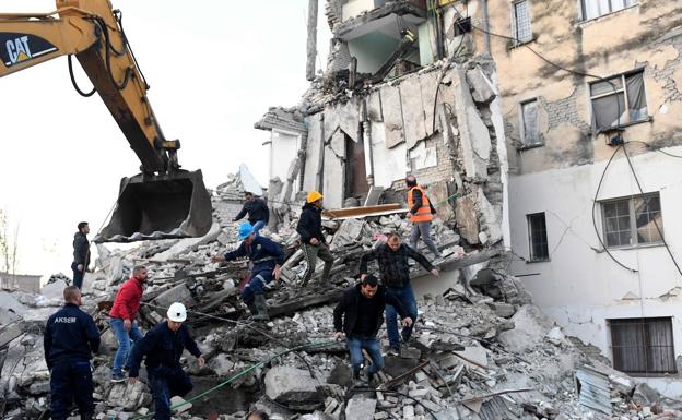 Los trabajadores de emergencia limpian los escombros en un edificio dañado en Thumane, a 34 kilómetros.