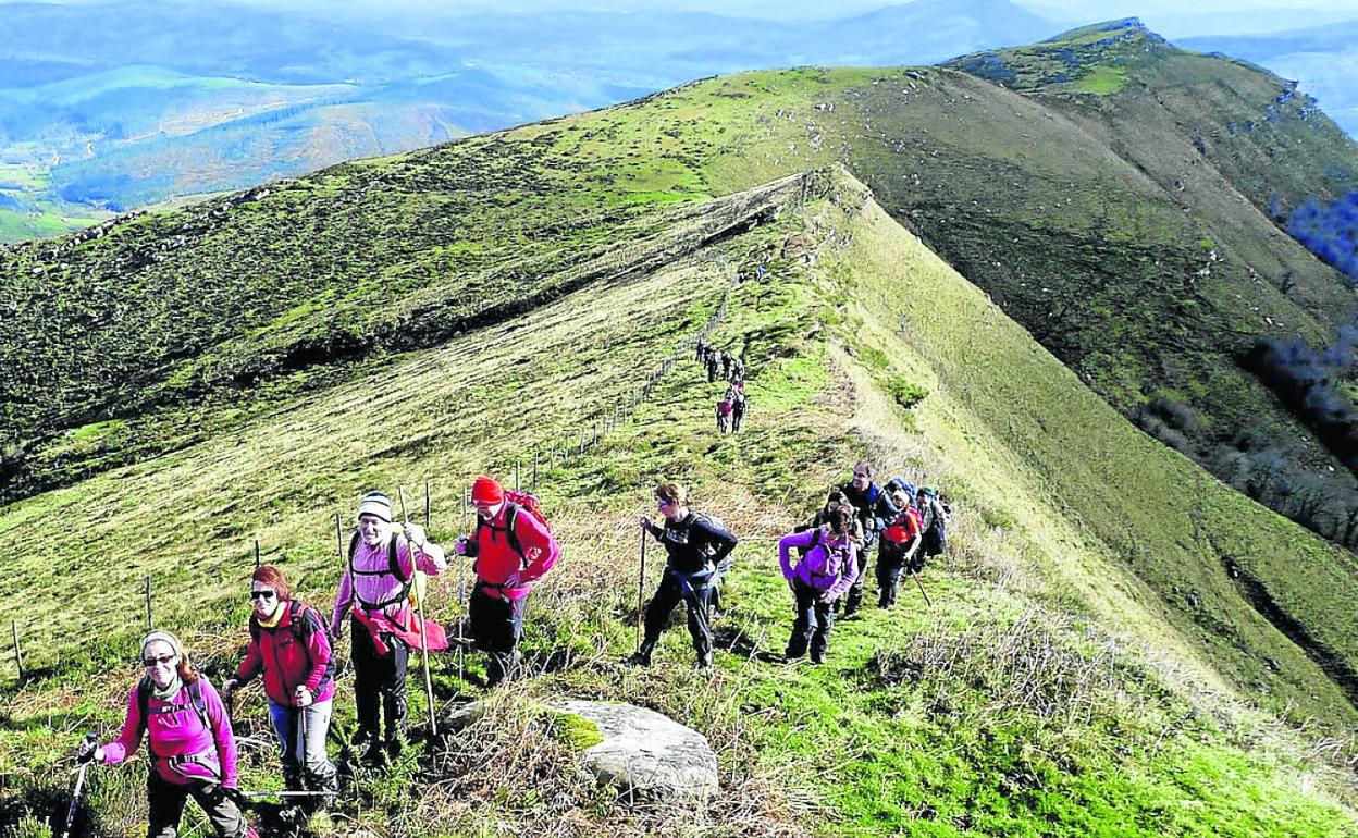 Un grupo de montañeros camina por la ruta a través del cordal del Escudo.