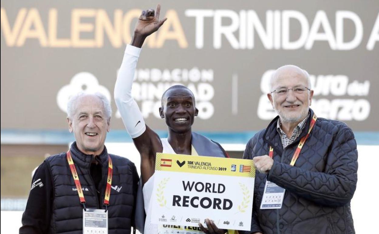 El atleta ugandés Joshua Cheptegei junto al director de carrera, Paco Borao (i) y el empresario Juan Roig.