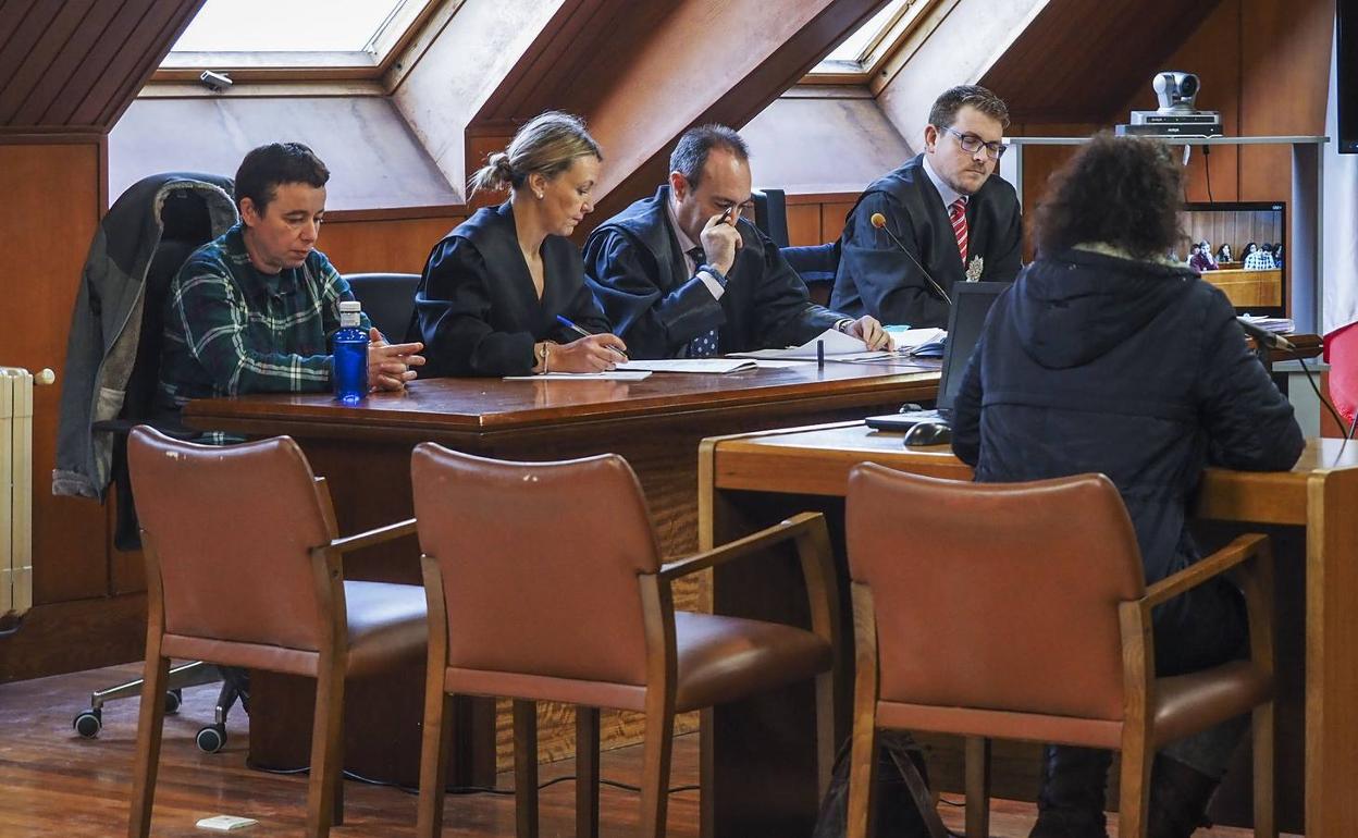 La acusada (primera por la izquierda) y su pareja, de espaldas, declarando como testigo en el juicio.