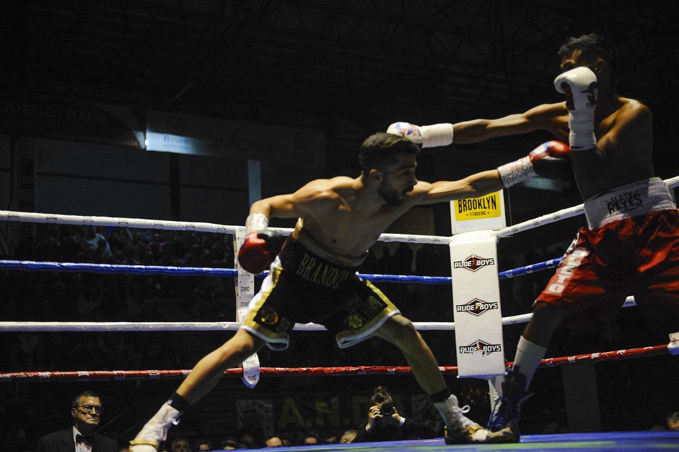 Una nueva velada con el Niño como protagonista y de nuevo un excepcional ambiente en el Vicente Trueba, con colas ya desde primera hora, antes de que comenzara la jornada, que tenía previsto su primer combate para las ocho de la tarde. Y ya desde el principio las gradas del pabellón mostraban una buena afluencia, destinada a multiplicarse para la cita estelar de la noche. También en los alrededores se aprecia el movimiento propio de estas ocasiones, en una noche de sábado en la que el deporte convive con la jornada de puente y fiestas en la Plaza Mayor y la Plaza Roja. En total, más de 2.000 personas para seguir con atención la tercera defensa del título del campeón torrelaveguense, siempre volcado con una ciudad que sabe devolverle el cariño.