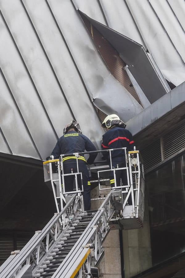 Los bomberos de Santander, asegurando las planchas metálicas del CEAR de Vela, desprendidas por el viento.