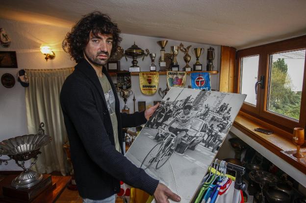 Alberto Fernández Saiz, ayer en su domicilio de Barros con un gran póster de su padre y sus trofeos y maillots. 