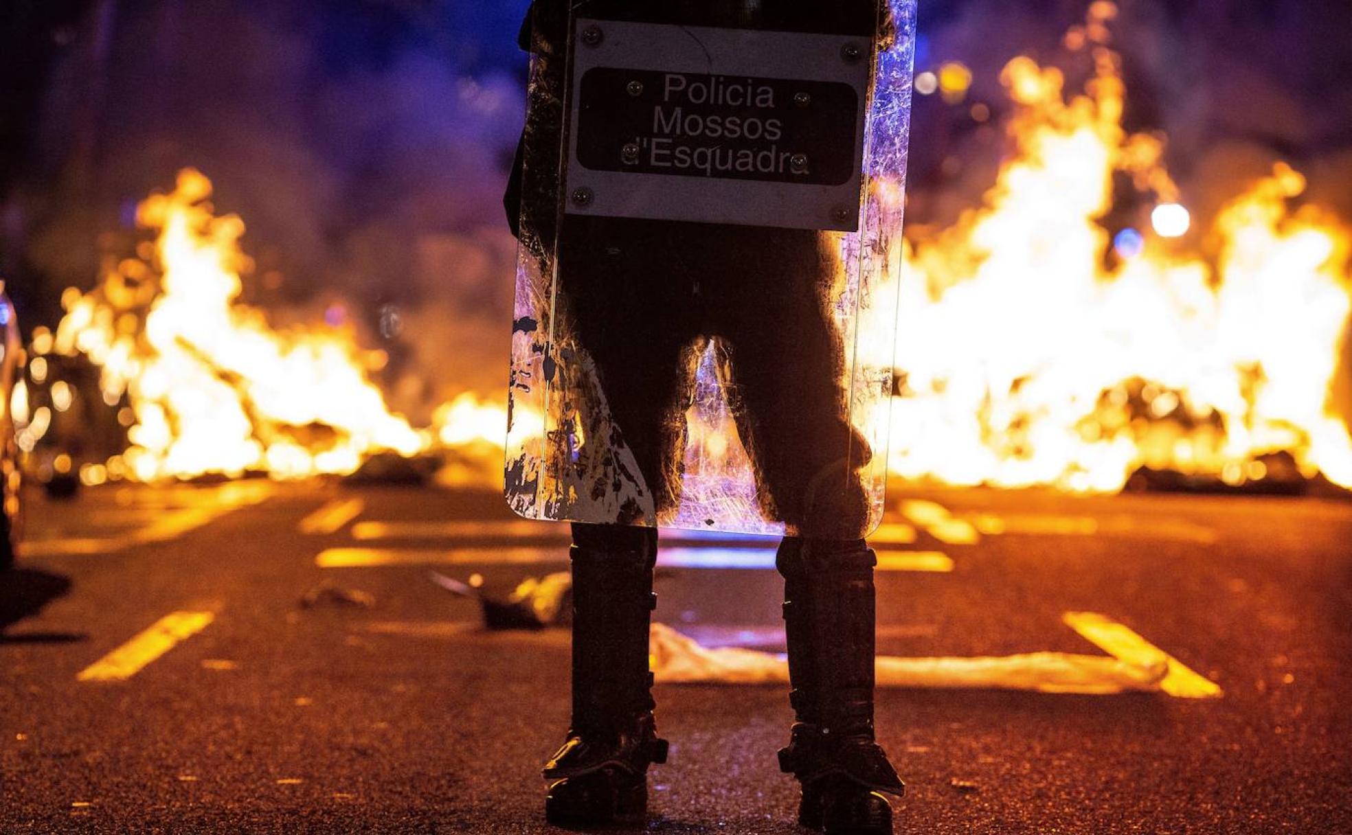 Un mosso, ante una barricadas en Barcelona. 