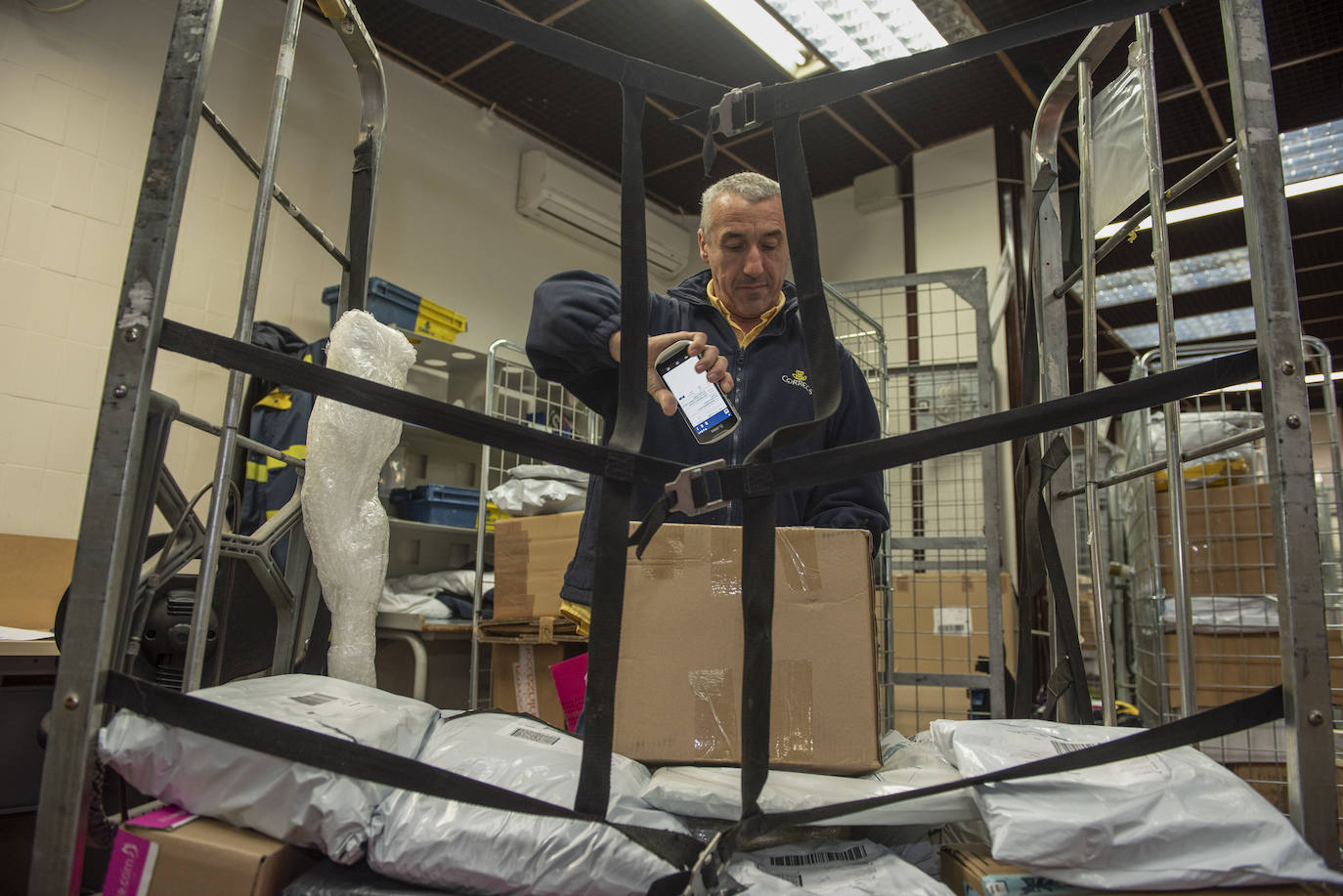 Un trabajador identifica la dirección de un envío con una tableta. 