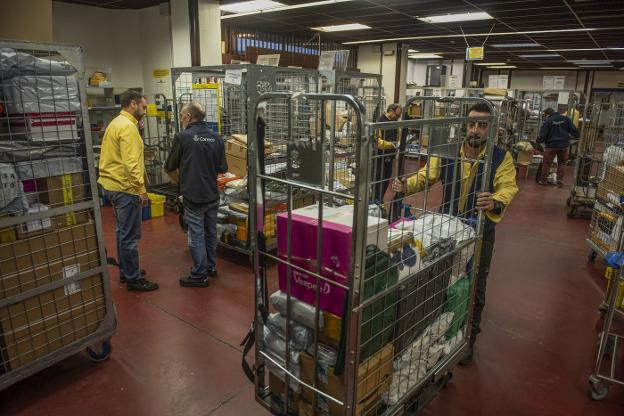 Empleados de Correos ordenan los paquetes por municipios a primera hora de la mañana en la sede de Santander.