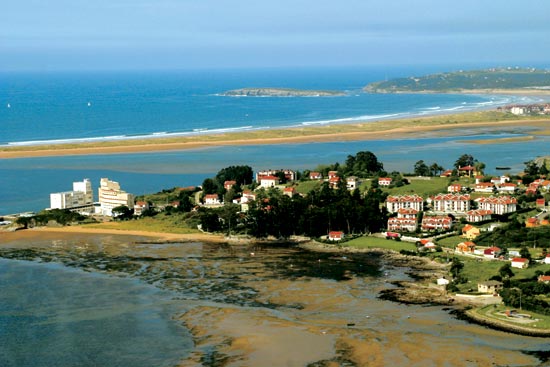 Localidad de Pedreña, con el campo de golf de La Junquera, a la derecha, y la playa del Puntal y la isla de Santa Marina, al fondo.