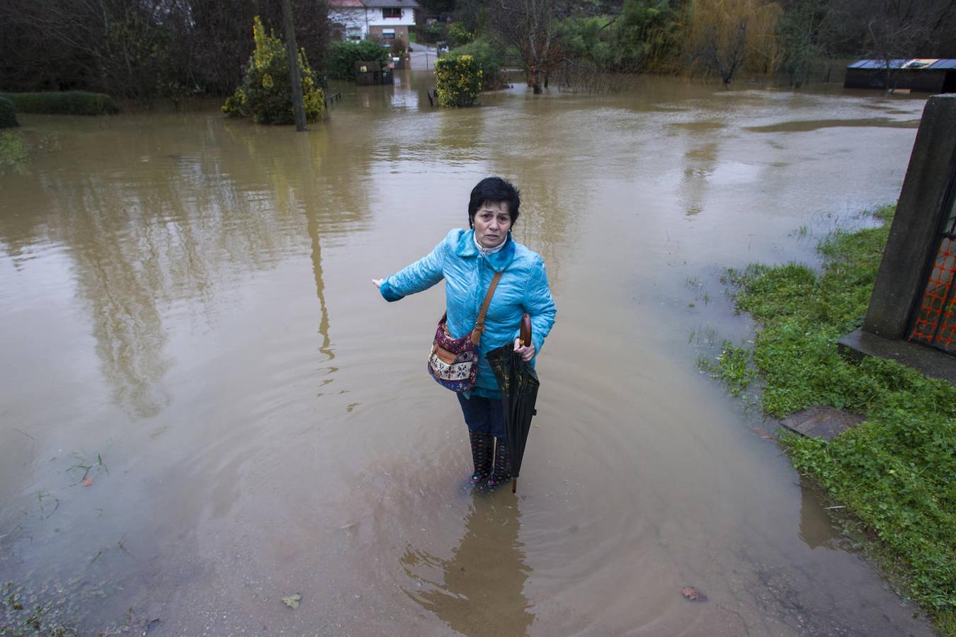 Una vecina camina entre las aguas en el barrio Navalín de Obregón por causa de las inundaciones que afectaron a finales del mes de enero a distintos puntos de Cantabria