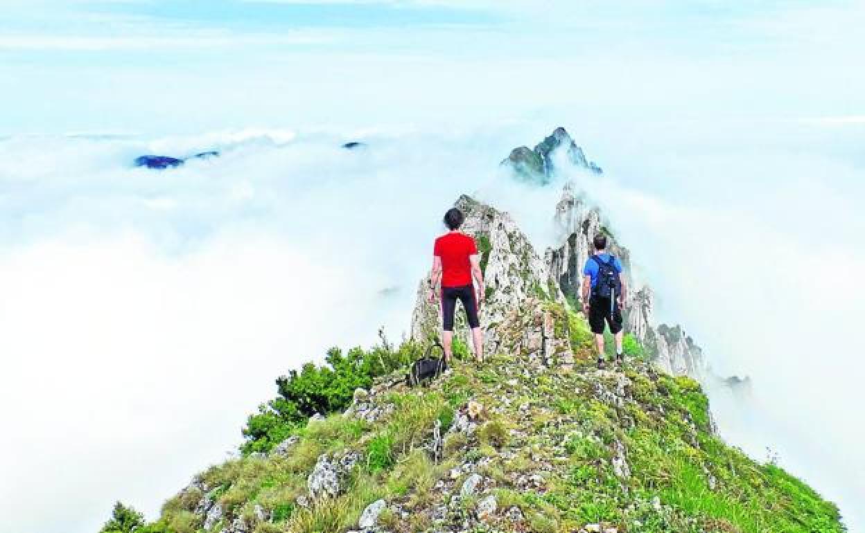 Dos montañeros crestean la cima de Monte Larrasa. 