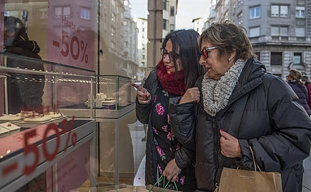 Paula y Elena, cargadas con varias paquetes, miran uno de los escaparates del centro de Santander. ¡