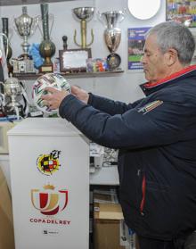 Imagen secundaria 2 - Arriba: Manuel Jerez, encargado del bar, con un grupo de seguidores.Abajo, a la izqueirda, un operario trabaja en la colocación de una de las gradas supletorias. A la derecha, Antonio Higuera, secretario del club, con el balón con el que se jugará.