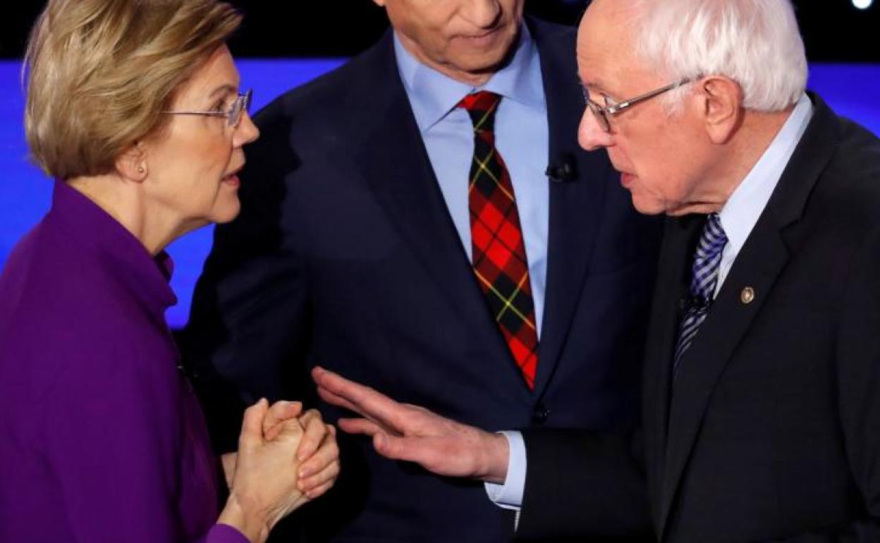 Elizabeth Warren habla con el senador Bernie Sanders. 