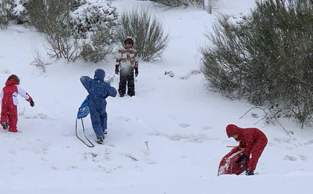 Varios niños juegan con la nieve en la subida a Brañavieja.