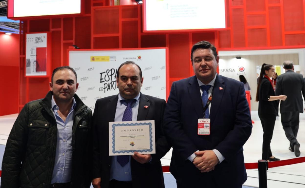 De izquierda a derecha, Juan Torre, presidente de la Junta Vecinal de Mogrovejo; Óscar Casares, alcalde de Camaleño, y Bernardo Colsa, director de Cantur, posan con el diploma obtenido por el pueblo cántabro. 