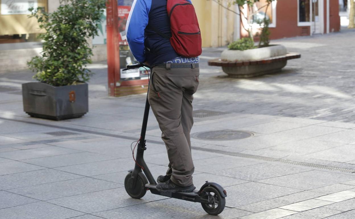 Un hombre circulando en un patinete eléctrico.