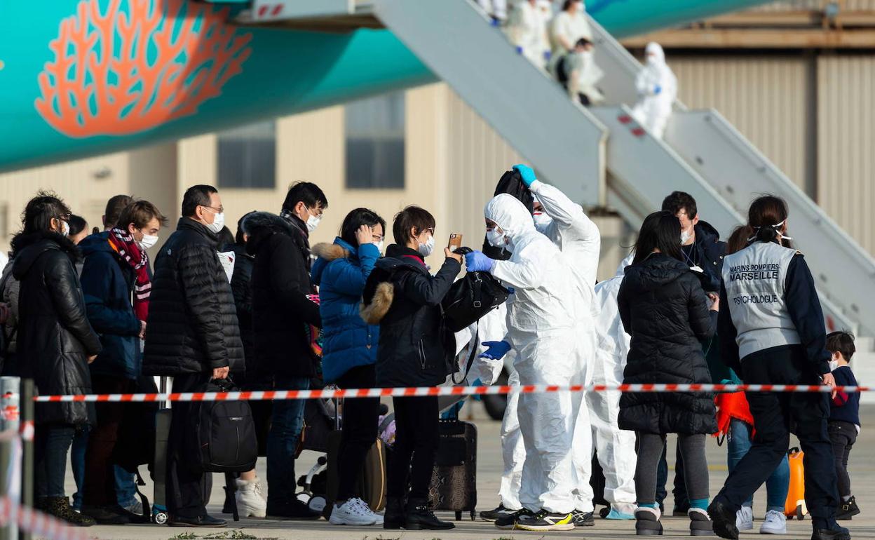 Pasajeros de origen chino al desembarcar en un avión en el aeropuerto de Marsella (Francia). 