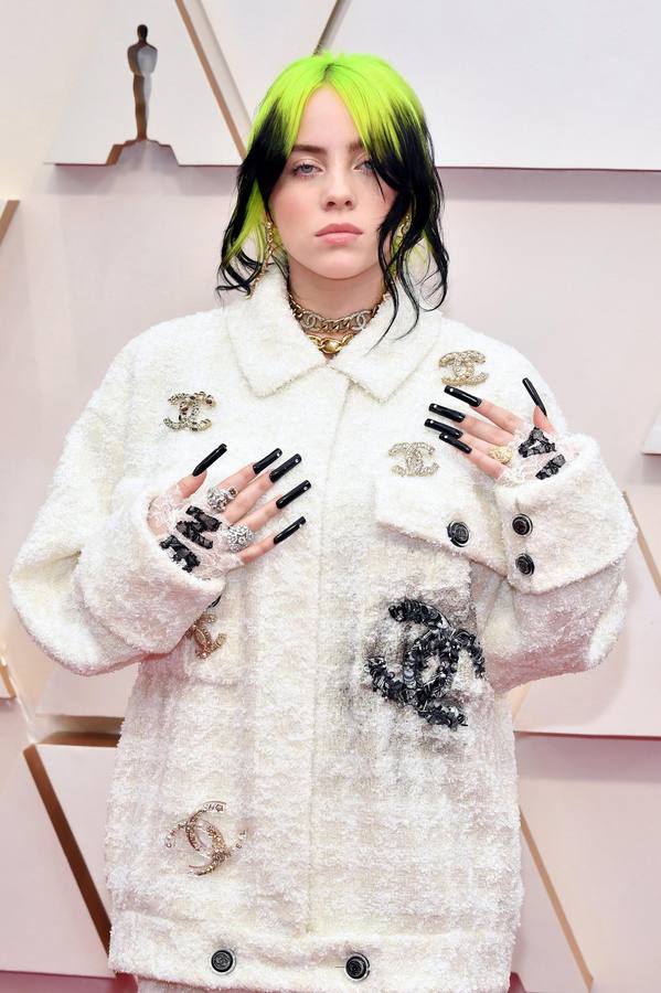 La cantante Billie Eilish apareció con un conjunto de dos piezas de Chanel. Mucha gente opina que no estaba a la altura de una gala de los Oscar, pero iba totalmente acorde a su estilo con el logo de la firma grafiteado. Otro de los detalles que no dejaron indiferente a nadie fueron sus largas uñas, al más estilo Rosalía, pintadas de color negro y adornadas con brillantes.