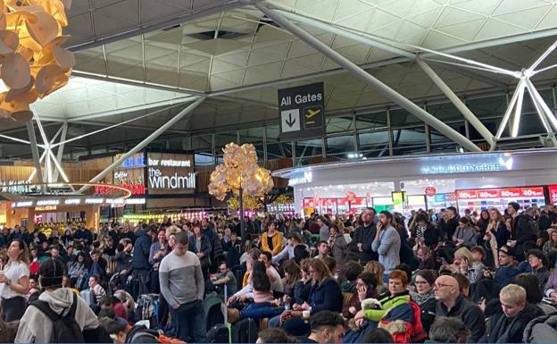 Imagen de la terminal del aeropuerto de Stansted, en la tarde del domingo, repleta de viajeros afectados por la cancelación de vuelos.