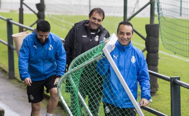 José Luis Oltra, portería en mano, se dirige a entrenar en la sesión de ayer en La Albericia.