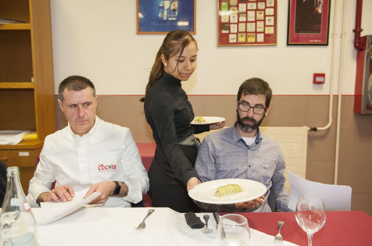 Una alumna de servicios presenta un plato al jurado. 