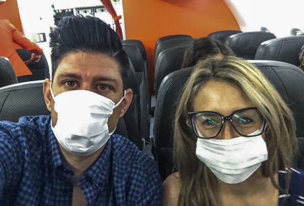 Ignacio Herrero y su mujer, con mascarillas, en el avión a Taiwán hace dos semanas.