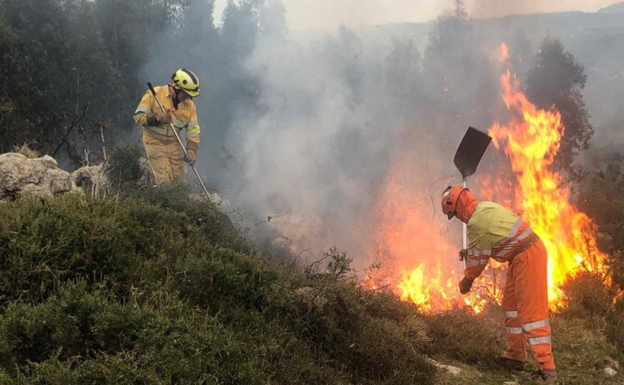 Imagen de archivo de dos agentes intentando extinguir uno de los fuegos provocados el pasado fin de semana.