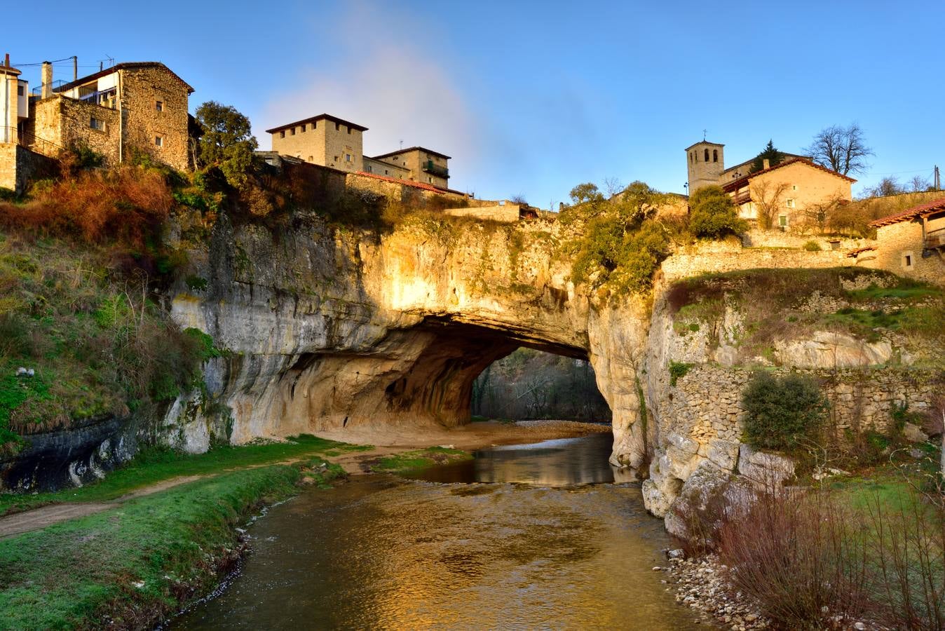 Puentedey, con su arco natural en la roca, bajo la luz de la hora dorada.