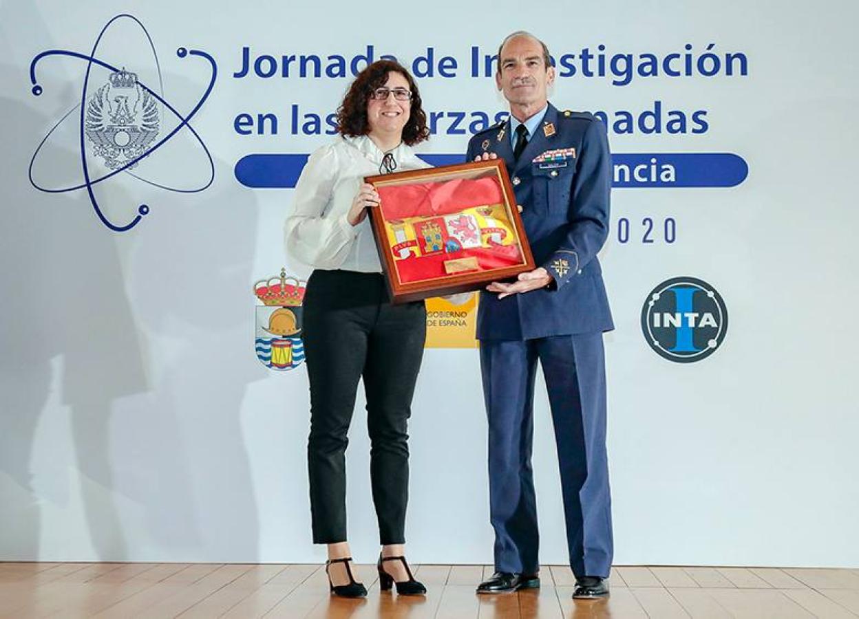 Alicia Calderón recogiendo la distinción de manos del director del INTA, el teniente general José María Salom.