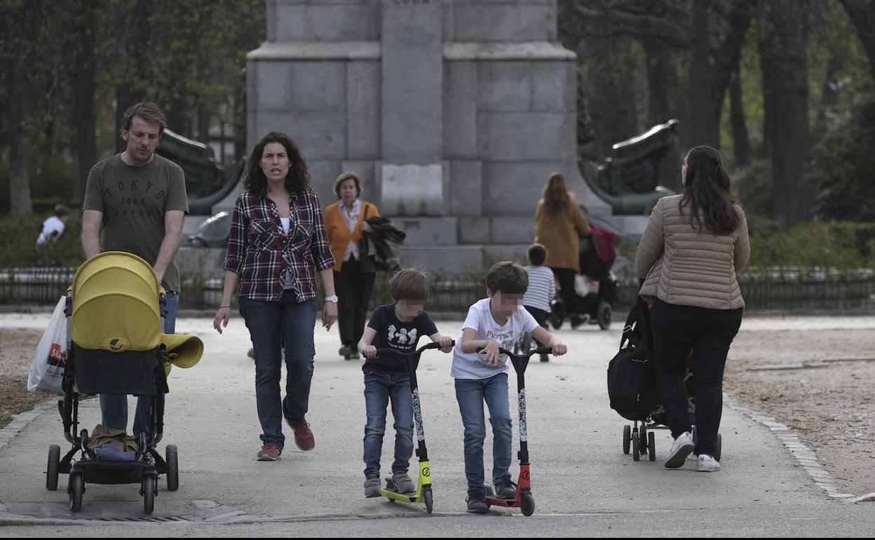 Unos padres pasean con sus hijos este miércoles por el madrileño parque del Retiro. 