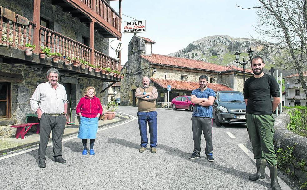 San Roque de Riomiera. Vecinos de San Roque y de Calseca (Ruesga) posan cada uno a un metro de distancia en un pueblo más vaciado que nunca, en el que la farmacia despacha por un ventanuco.