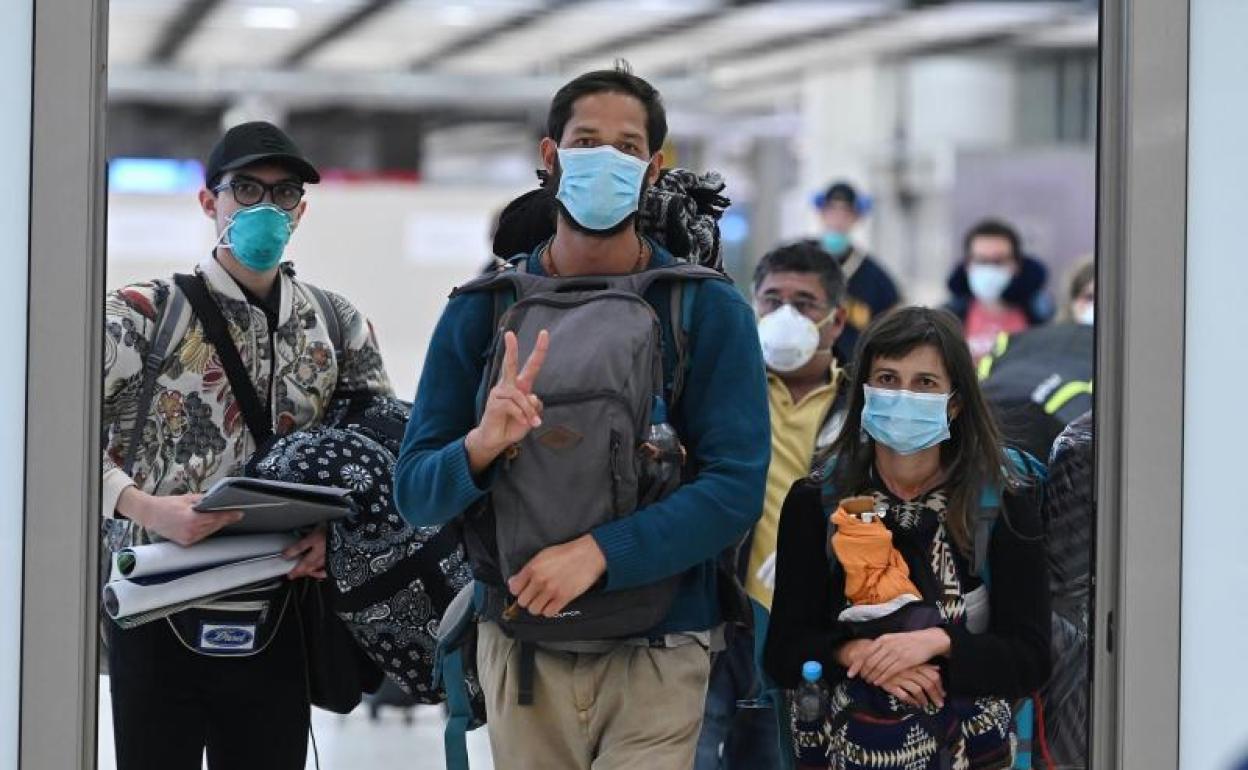 Pasajeros procedentes de Ecuador llegan al aeropuerto de Barajas en un vuelo de Iberia.