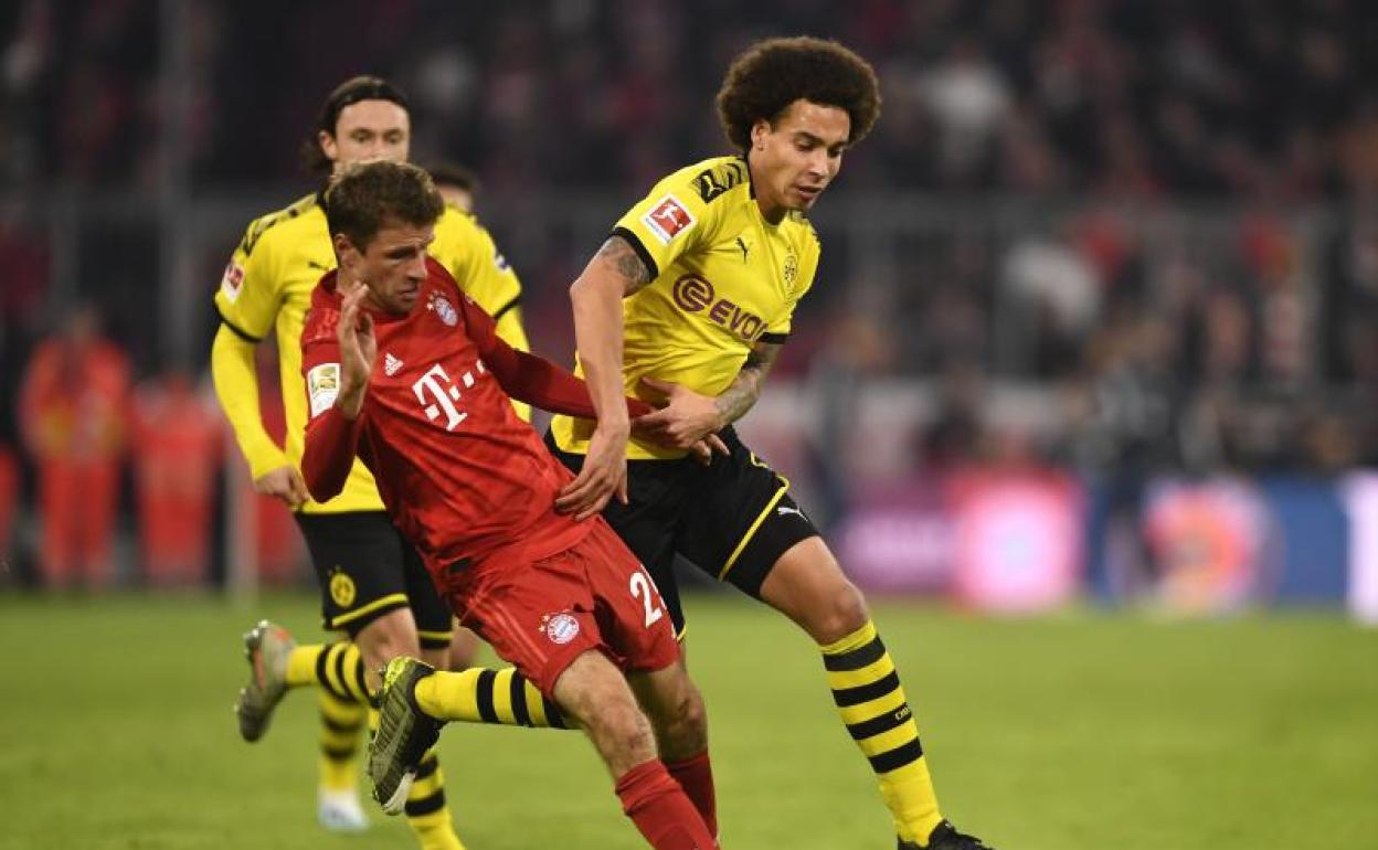 Thomas Müller, del Bayern, y Axel Witsel, del Dortmund, disputan un balón en un partido de la Bundesliga. 