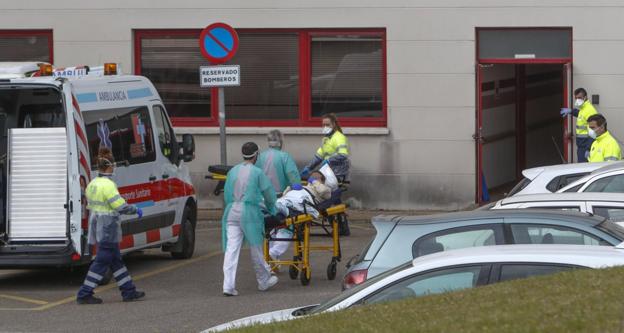 Personal del hospital y técnicos sanitarios de las ambulancias coordinan sus trabajos para trasladar a los contagiados. 