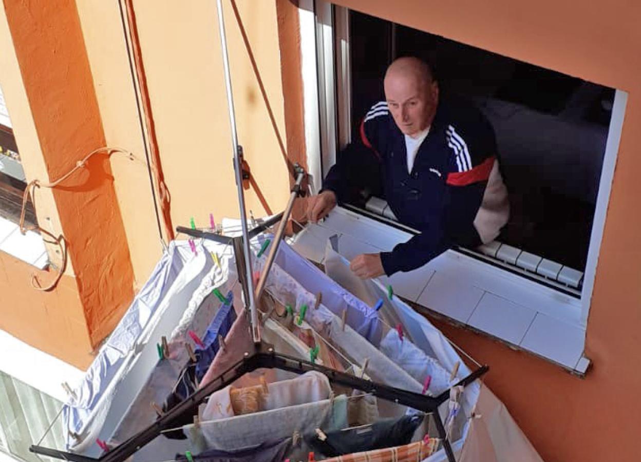 Nuestro compañero y fotógrafo Antonio San Emeterio, 'Sane' para todos, tendiendo la ropa desde una de las ventanas de su casa.