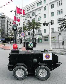 Imagen secundaria 2 - Clientes con máscaras pasan frente a un detector térmico en una superficie comercial de Bangkok | Una mujer recorre una calle de Pekín | La Policía de Túnez patrulla por las calles de la capital en busca de focos de calor. 