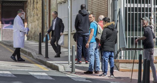 Los usuarios de la Cocina Económica hacen fila para recoger su bolsa de alimentos. roberto ruiz