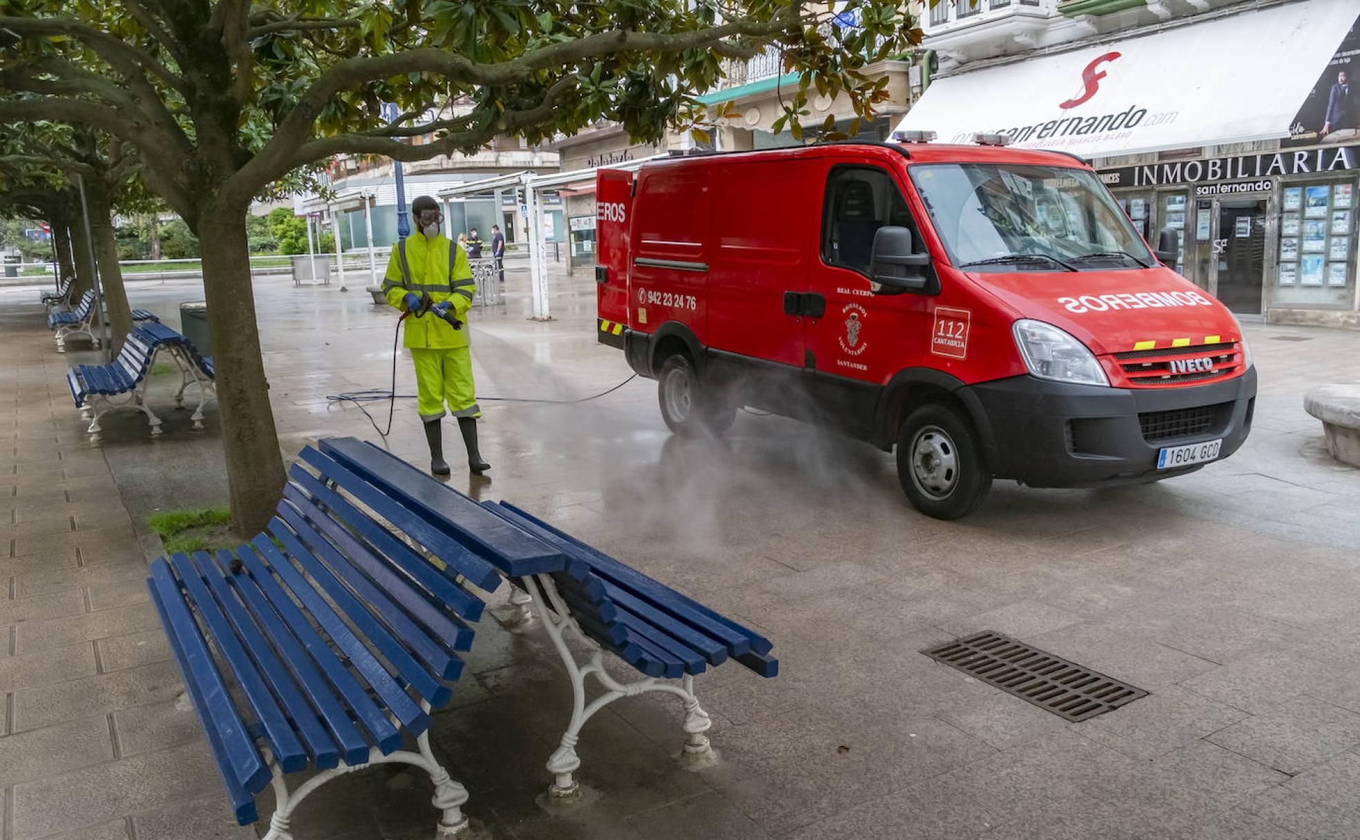 Un bombero voluntario, durante la desinfección de la calle Burgos, de Santander