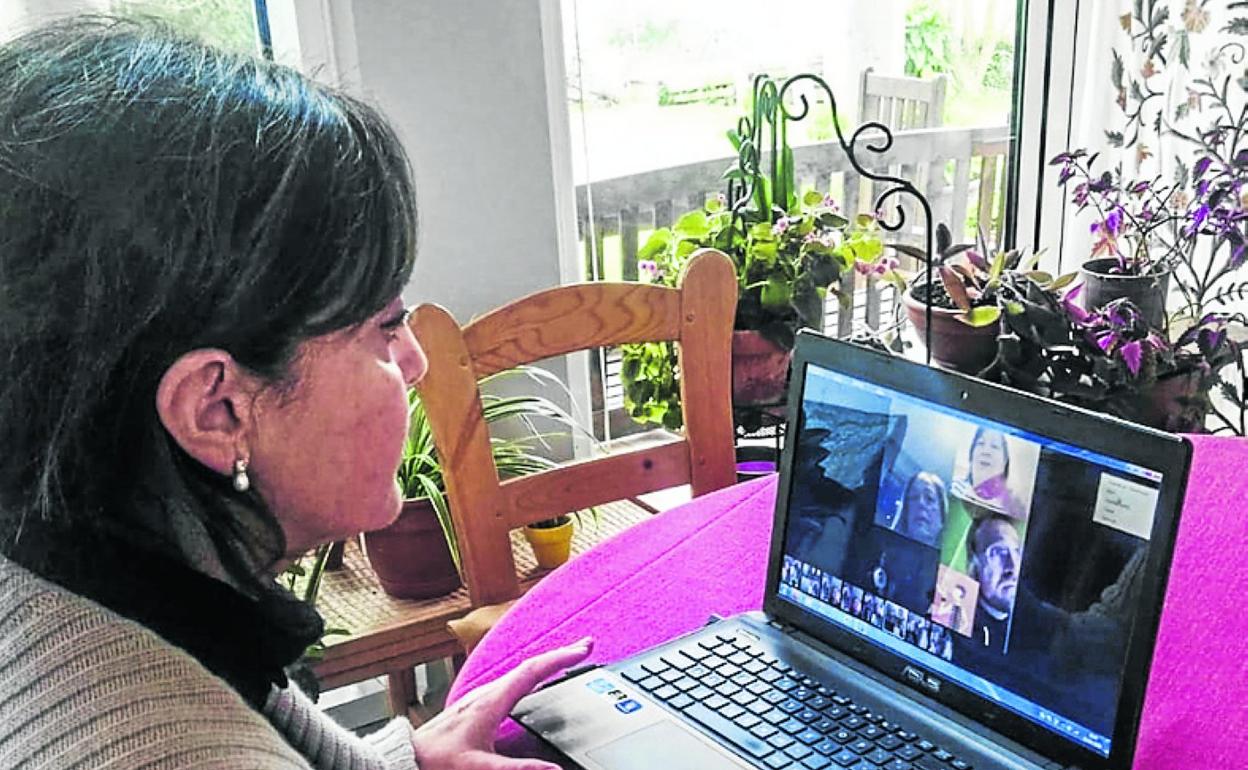 La directora de la Biblioteca Municipal de Camargo, Ana Isabel Calvo, conversa a través del ordenador con algunos miembros del Club de Lectura. 