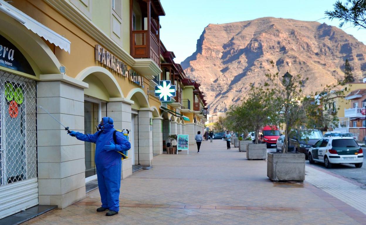 Un empleado municipal desinfecta una calle de una localidad en la isla de La Gomera.