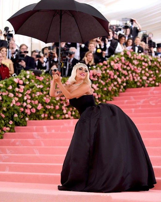 Lady Gaga y su look '4 en 1'. Con ayuda de unos 'performers' que llevaban paraguas se quitó el traje para mostrar un vestido palabra de honor de corte princesa en color negro.