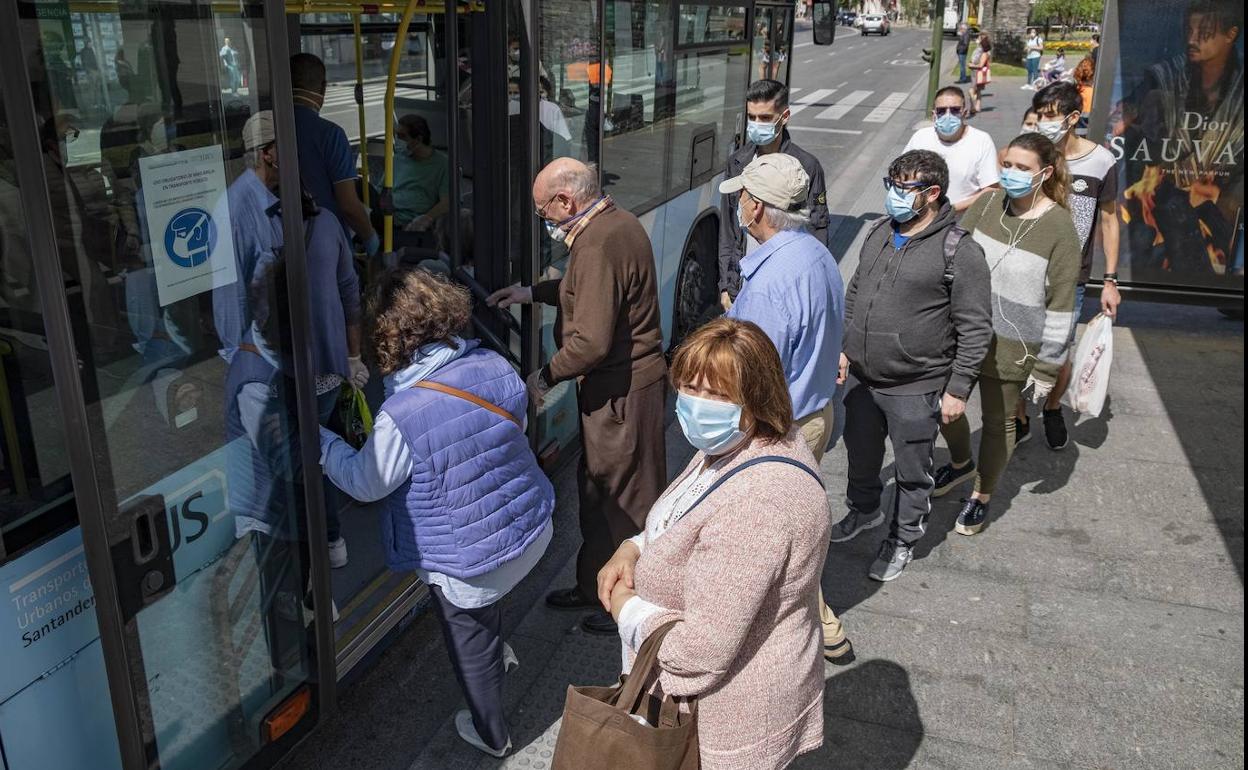 Ciudadanos cogiendo el autobús en Santander, este martes.