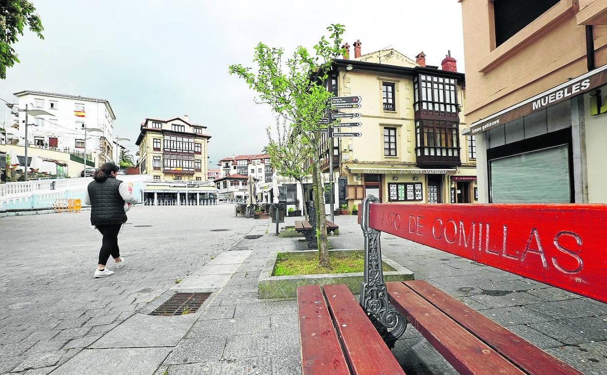 Comillas. Una mujer atraviesa la plaza del corro Campíos, vacía por el confinamiento en los días pasados. j