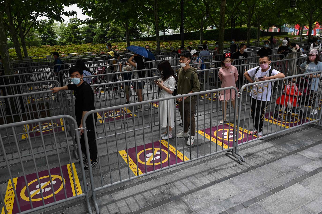 Disneyland Shanghái se ha convertido en el primer parque temático del mundo en retomar su actividad después del parón provocado por la crisis del coronavirus. La reapertura marcará las pautas en el resto de sus instalaciones en Estados Unidos, Francia y Asia, y se ha llevado a cabo con medidas de seguridad para evitar las aglomeraciones y contagios: aforo al 30% de su totalidad, bandas amarillas en los accesos para mantener la distancia mínima interpersonal, uso obligatorio de mascarilla y tomas de temperatura para clientes y empleados.