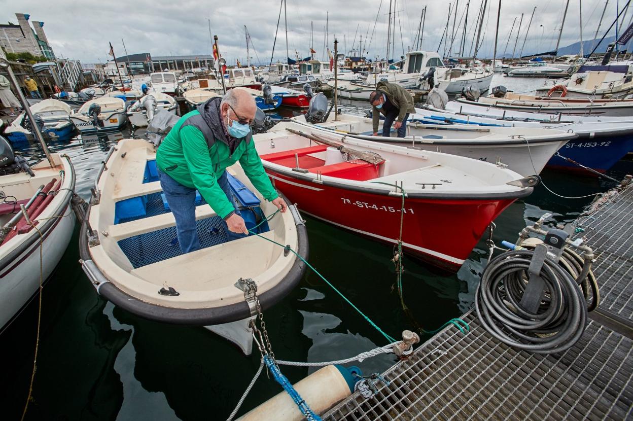 Propietarios de pequeñas embarcaciones atracadas en Puertochico revisan sus botes. 