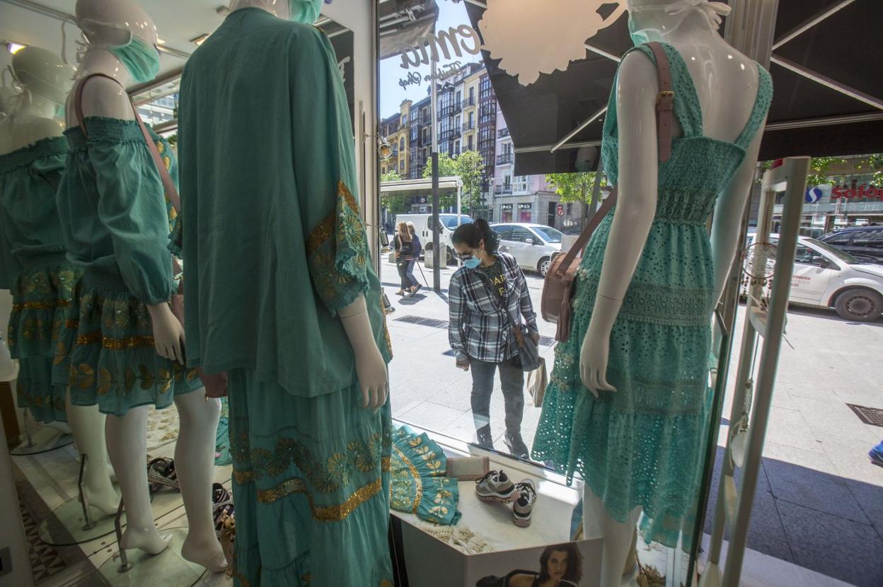 Una mujer observa el escaparate de una tienda de Jesús de Monasterio, en Santander . 