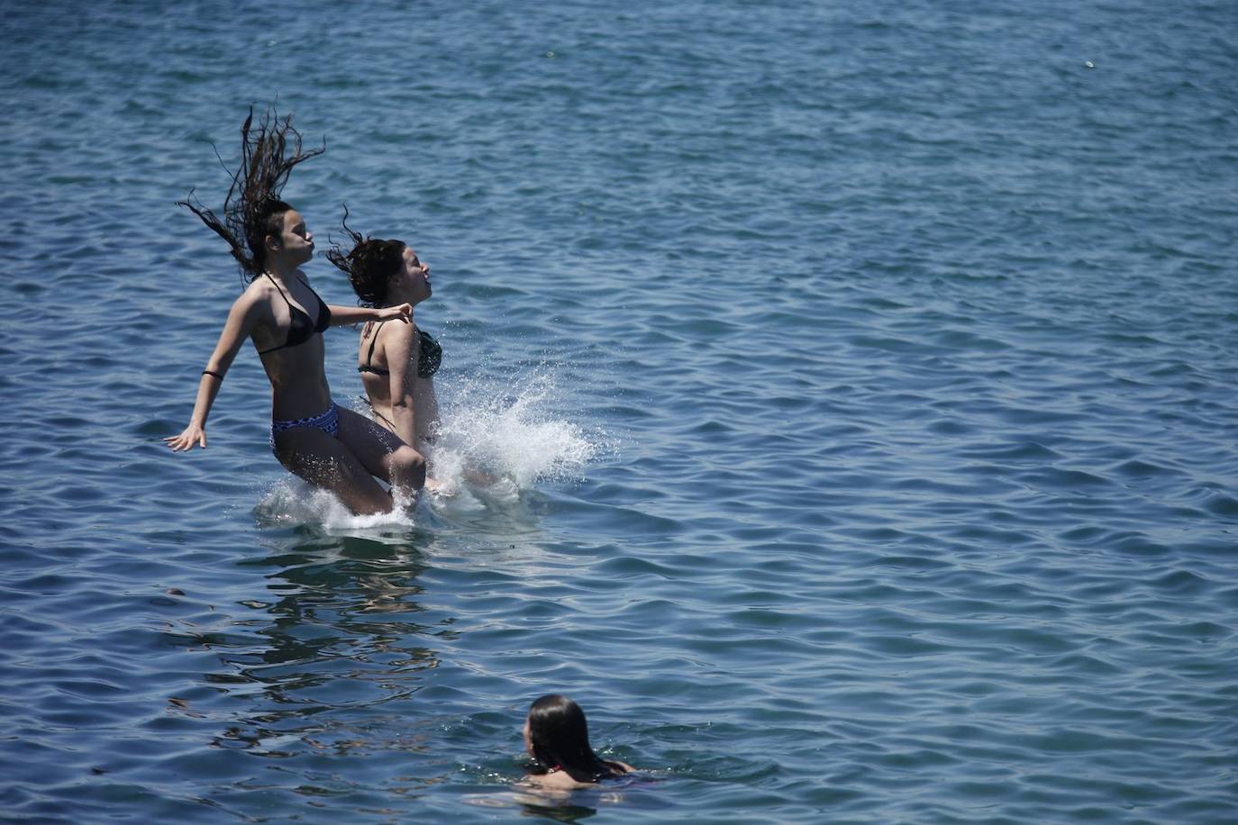 Aspecto que presentan este sábado las playas de El Sardinero y de la bahía de Santander, con muchos bañistas, gente paseando por la orilla, disfrutando del mar y tomando el sol.