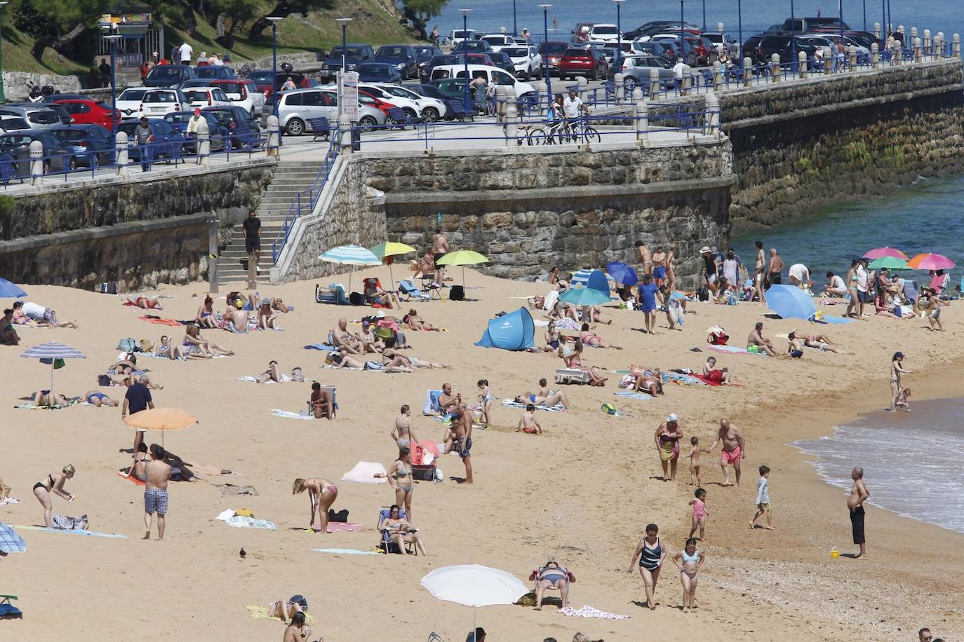 Aspecto que presentan este sábado las playas de El Sardinero y de la bahía de Santander, con muchos bañistas, gente paseando por la orilla, disfrutando del mar y tomando el sol.